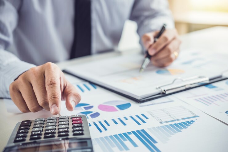 Contabilista utiliza calculadora para processamento de dados e análise de rentabilidade.